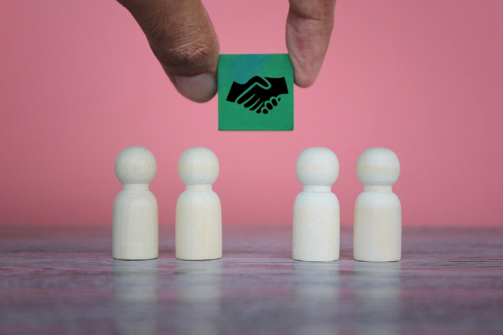 wooden-dolls-and-wooden-cube-with-handshake-icon
