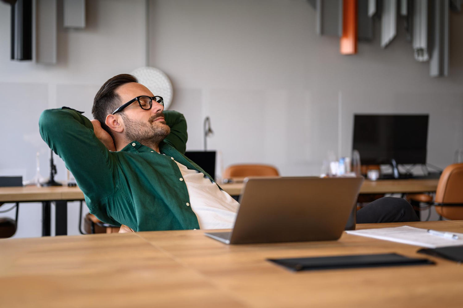 Man leaning back in chair with laptop