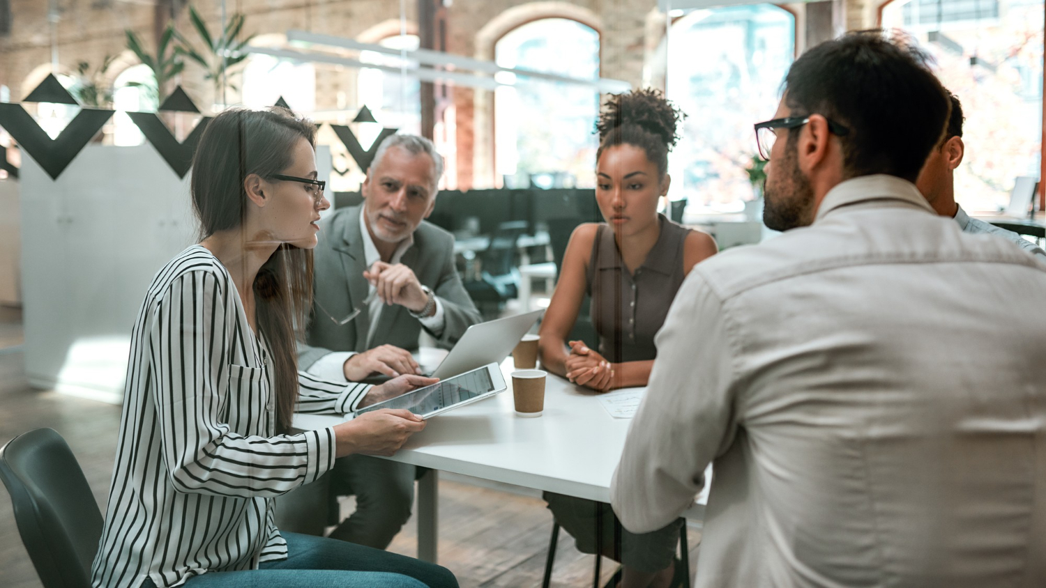 People gathered around a table in discussion.